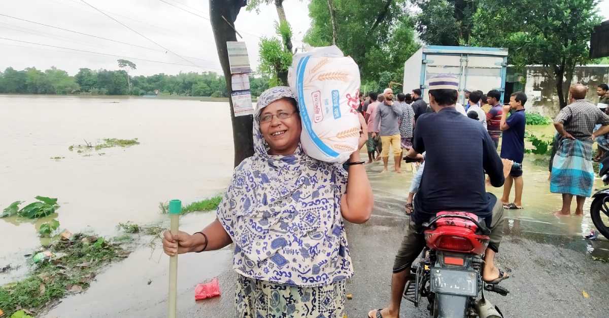 দুর্ভোগকালীম সময়ে ত্রাণ সহায়তা পেয়ে খুশি এক বানভাসি নারী। ছবি- আই নিউজ