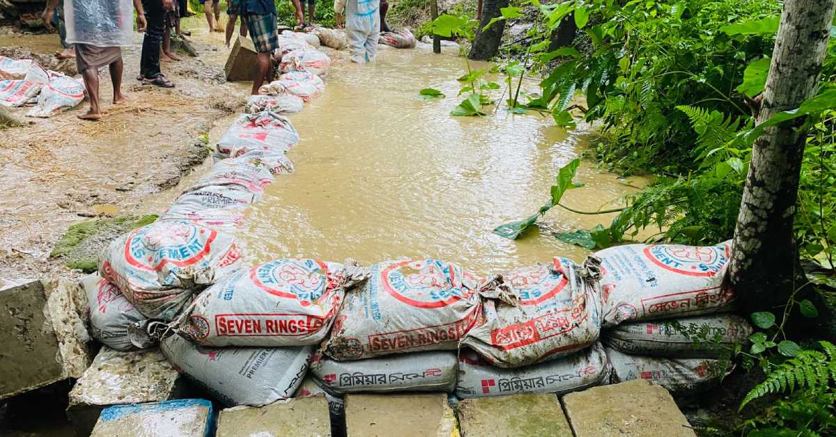 মৌলভীবাজারে বালুর বস্তা দিয়ে বাঁধের ভাঙন ঠেকানোর চেষ্টা।